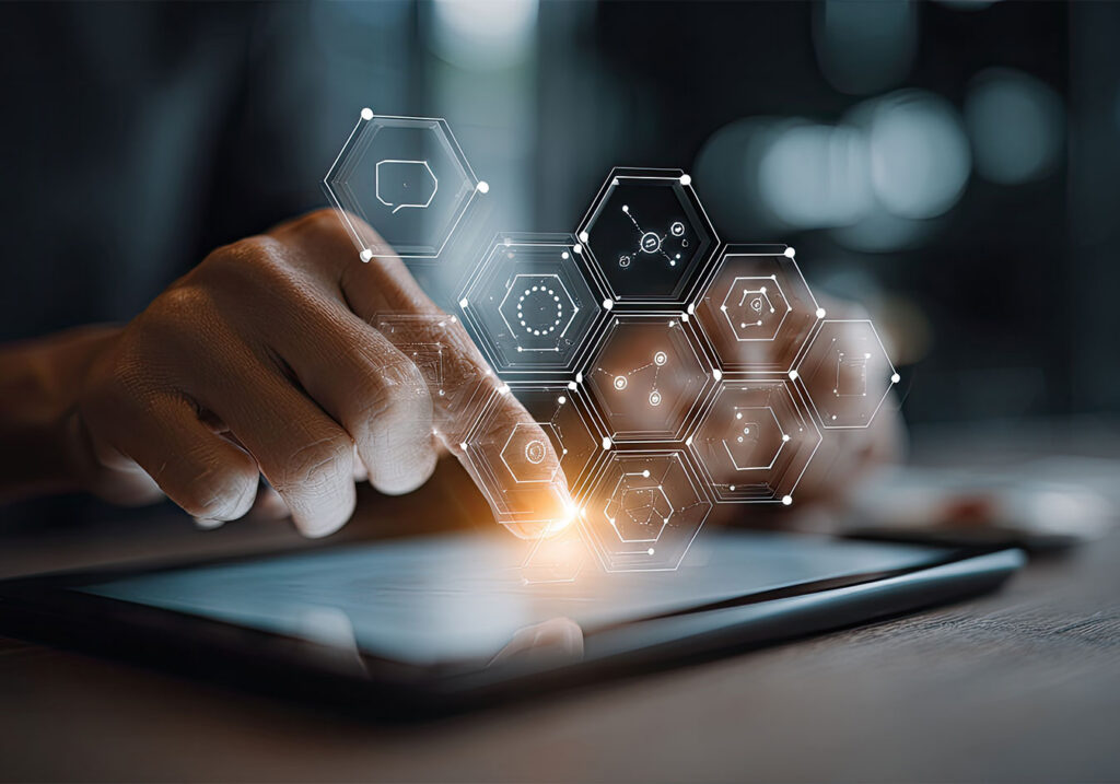 Close-up of a hand touching a tablet with glowing hexagonal digital interface icons, representing data, connectivity, and enterprise technology transformation